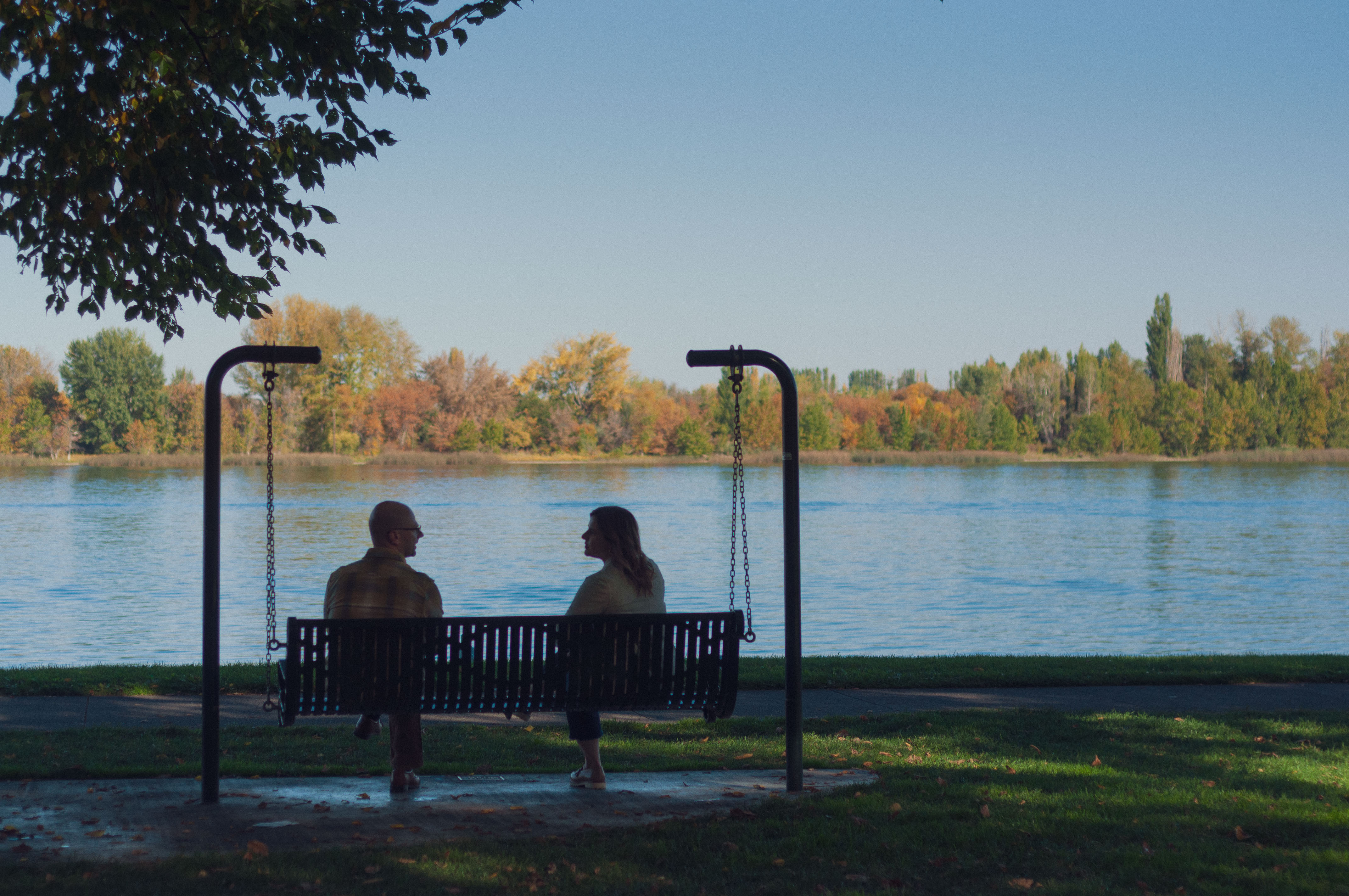 Steven and Jessica Wallace on a riverside swing